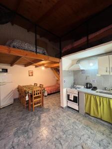 Una cocina y un comedor con una mesa y una cama. en Piltri duplex, en El Bolsón