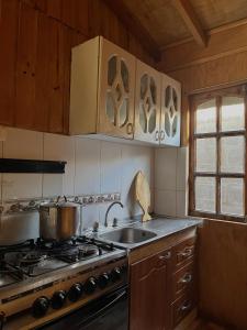 eine Küche mit Herd und Spüle in der Unterkunft Cabaña AlbaMarina - Pichilemu in Pichilemu