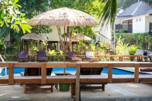 a table with chairs and umbrellas next to a pool at Baan Sawasdee Resort in Ko Lanta