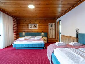 two beds in a room with wooden walls at Bergzeit Hollersbach XL in Hollersbach im Pinzgau
