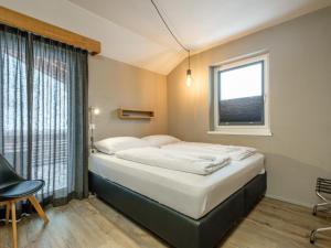 a bedroom with a bed and a window at Hirnreit in Leogang