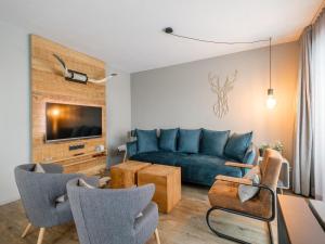 a living room with a blue couch and chairs at Hirnreit in Leogang