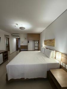 een groot wit bed in een kamer met een keuken bij Flat em Hotel in Manaus