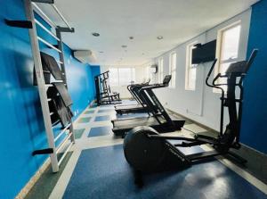 a gym with several tread machines in a blue room at Flat hotel Blue tree no adrianopolis Até 4 pessoas in Manaus