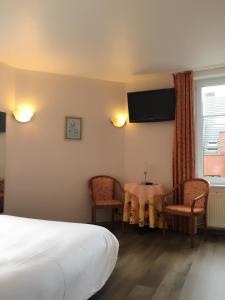 ein Hotelzimmer mit einem Bett, einem Tisch und Stühlen in der Unterkunft Hotel Claridge in Blankenberge