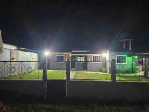 une maison la nuit avec des lumières sur une clôture dans l'établissement Casa da Família Flores, à Rosário do Sul