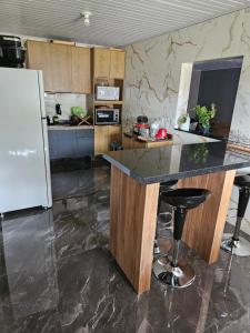 Il comprend une cuisine équipée d'un comptoir et d'un réfrigérateur. dans l'établissement Casa da Família Flores, à Rosário do Sul