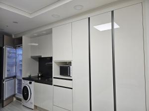eine Küche mit weißen Schränken und einer Waschmaschine und einem Trockner in der Unterkunft 인천공항 근접 프라이빗 원룸 in Incheon
