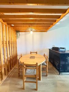 un tavolo e sedie in legno in una stanza con piano cottura di Evasion Douce Désign a Prénatier Altre 3 foto