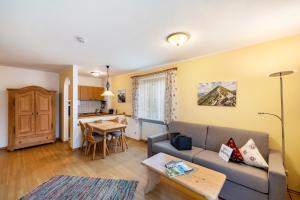 a living room with a couch and a table at Fewo Brünnstein - Zimmer 6 in Oberaudorf