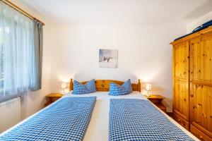 a bedroom with two blue and white beds and a window at Fewo Brünnstein - Zimmer 6 in Oberaudorf