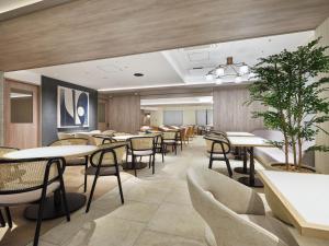 ein Esszimmer mit Tischen und Stühlen in der Unterkunft Premium hotel MONday MAIHAMA View 1 in Tokio
