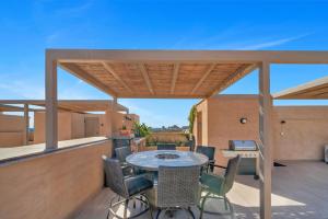 a patio with a table and chairs on a deck at Bohari Las Arenas in Cabo San Lucas