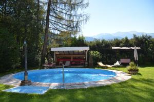 una piccola piscina in un cortile con tavolo e sedie di Schloss Münichau a Reith bei Kitzbühel