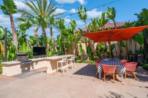 eine Terrasse mit einem Tisch, Stühlen und einem Grill in der Unterkunft New Luxury 1BR Stay in the Heart of Irvine in Lake Forest