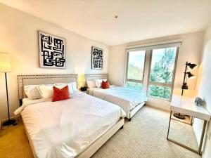 ein Schlafzimmer mit zwei Betten und einem Fenster in der Unterkunft New Luxury 1BR Stay in the Heart of Irvine in Lake Forest + 26 Fotos