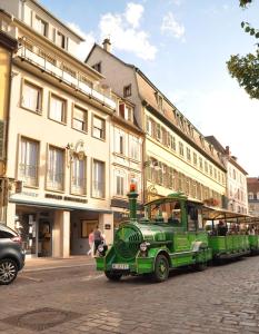 コルマールにあるAppartement duplex climatisé avec terrasse "HANSI"の建物前の路上に停車する緑のバス