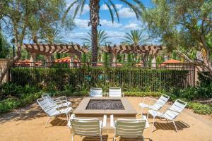 Eine Gruppe weißer Stühle, ein Tisch und ein Brunnen in der Unterkunft New Luxury 1BR Stay in the Heart of Irvine in Lake Forest