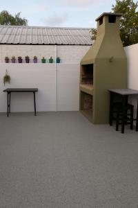 casa super comoda para 6 personas Miramar في ميرامار: فناء مع طاولة وجدار به نباتات