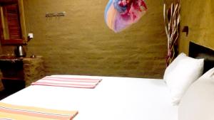 1 dormitorio con 1 cama con una flor en la pared en Golden Nature Cottage, en Udawalawe