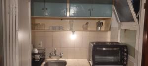 uma pequena cozinha com pia e micro-ondas em 4 Mares em Punta del Este mais 15 fotografias