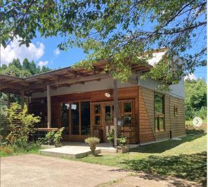 a small house with a large glass door at Private Forest Cottage for Two, Organic Lifestyle in Bungoono