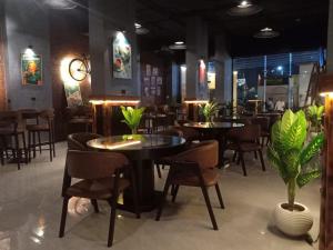 a dining room with tables and chairs and plants at Pyramids Gem Plaza Hotel in Cairo