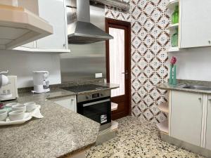 a kitchen with white cabinets and a stove top oven at Vistamar Porto Cristo in Porto Cristo