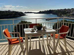 a table and chairs on a balcony with a view of the water at Vistamar Porto Cristo in Porto Cristo