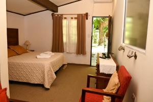 洛斯奥尔尼约斯Alta Montaña Hosteria&Apart的一间卧室，里面有一张床、一把椅子和一扇窗户 更多88张照片