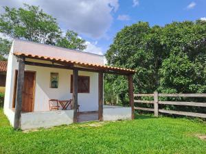 a small house in a field with a fence at Pousada e Restaurante Morro Alto in São João Batista do Glória