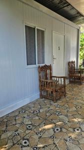 een veranda met twee houten banken in een huis bij Rooms in Apo-estin in Cangatuyom