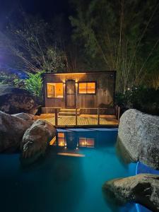 una casa con una piscina de agua con rocas en Camping & Cabanas Ilhabela, en Ilhabela