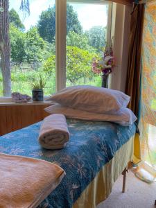 a bedroom with a bed with pillows and a window at River Song Retreat Golden Bay in Onekaka +34 photos