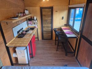 una cocina con una encimera y una mesa en una casa pequeña en Camping & Cabanas Ilhabela, en Ilhabela