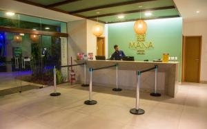 a man sitting at a counter in a lobby at Mana Beach Experience B019 in Porto De Galinhas +192 photos