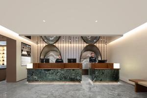 two people sitting at a counter in a lobby at Atour Hotel Shanghai Wujiaochang Wanda Plaza in Shanghai