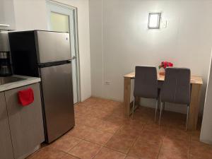 a kitchen with a refrigerator and a table with chairs at Puerta al Tren apartamento in San Juan