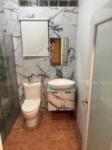 a bathroom with a toilet and a sink at Puerta al Tren apartamento in San Juan