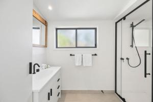 a white bathroom with a sink and a shower at Glenkeen Farm and Cabins in Bellbrae