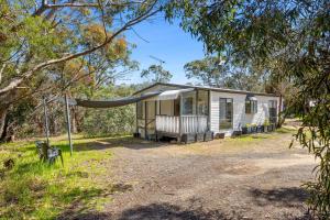 a mobile home in the woods with a canopy at Glenkeen Farm and Cabins in Bellbrae