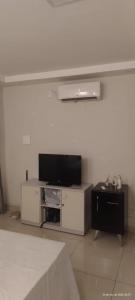 ein Wohnzimmer mit Flachbildfernseher und Tisch in der Unterkunft Pousada Horbis in Guarabira + 8 Fotos