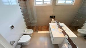 a bathroom with two toilets and a sink and a shower at Espora 343 in Punta Alta +19 photos