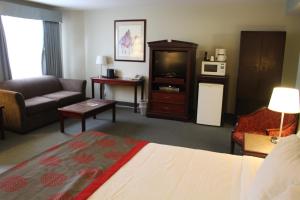 a hotel room with a bed and a couch at Harrison Lake Hotel in Harrison Hot Springs