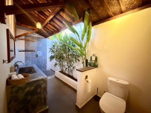 a bathroom with a toilet and a sink at Joglo Villas Uluwatu - Tropical Oasis in Uluwatu +26 photos