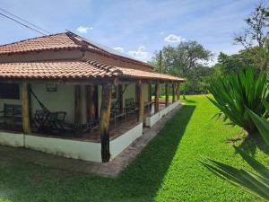 a small house with a roof on a green lawn at Pousada e Restaurante Morro Alto in São João Batista do Glória