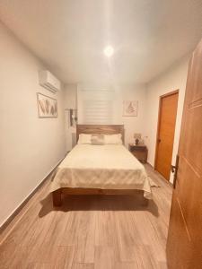 a bedroom with a bed and a wooden floor at El descanso in Higuey