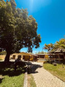 瓜拉廷格塔Chácara charmosa com piscina, campo de futebol的前面有一棵树的建筑物