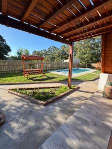 un patio con cenador y mesa de picnic en Alpinas el verano, en Mar del Plata