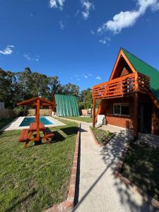 una cabaña de madera con una mesa de picnic y una mesa de picnic en Alpinas el verano, en Mar del Plata